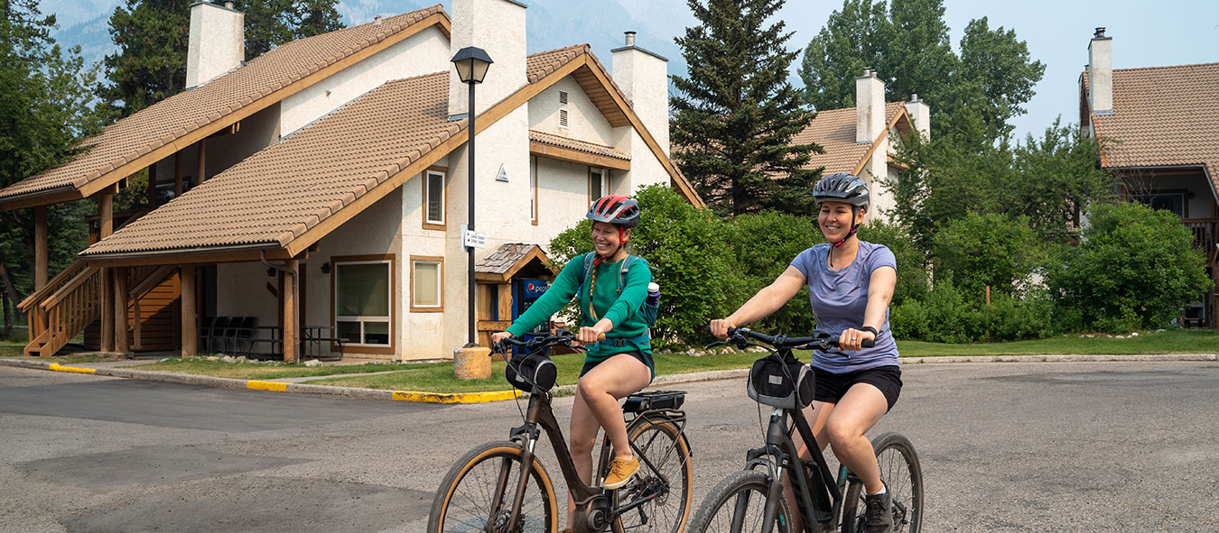 Two girls biking side by side