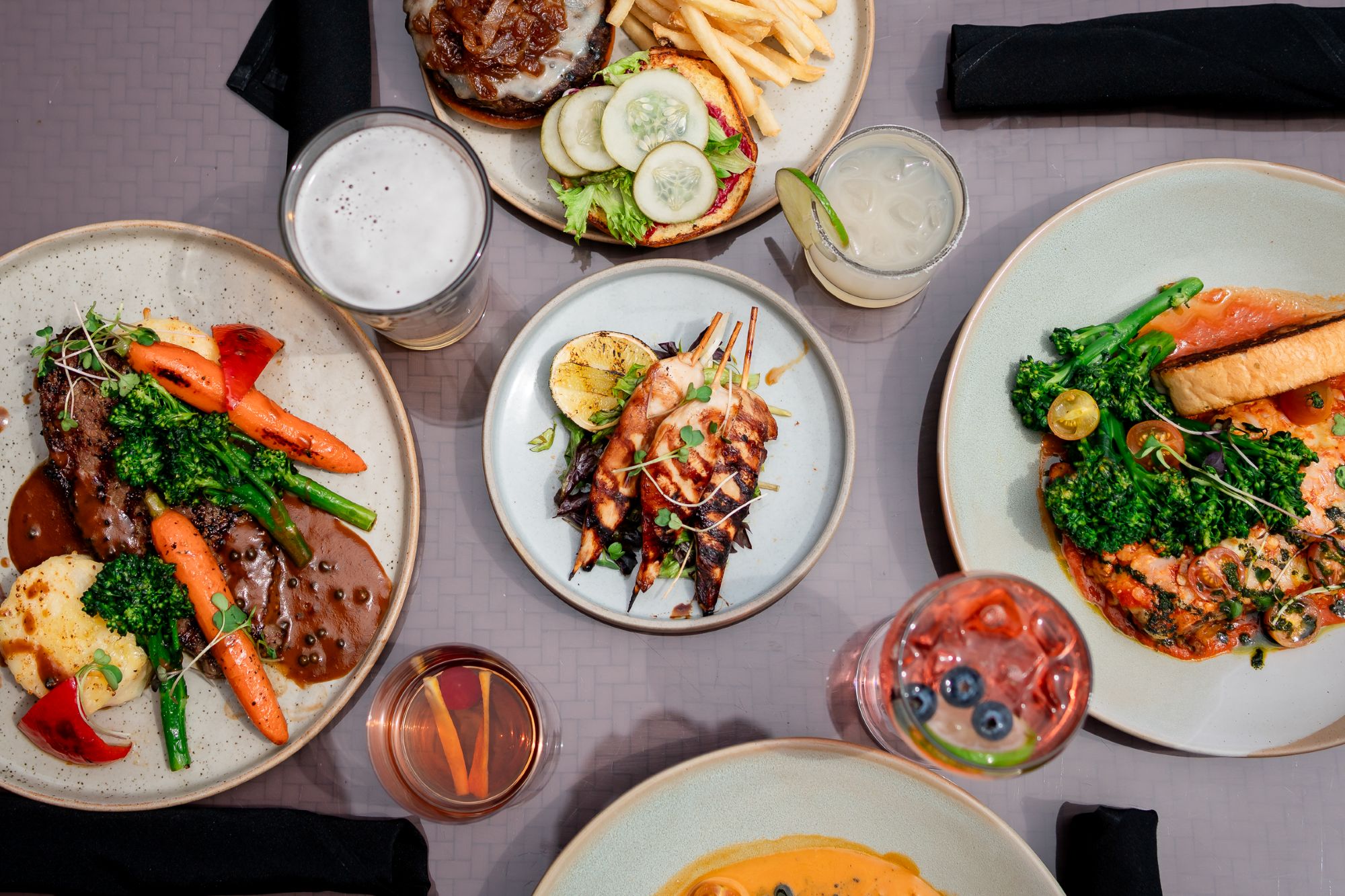Summer dinner menu at Alpha Bistro, Banff Rocky Mountain Resort, featuring the Elk Burger and Chef Raj's Fire Burrata.